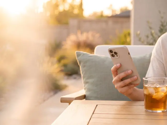 A guest checking a phone on a sunny patio